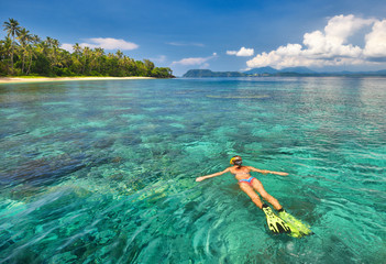 Canvas Print - woman snorkelling in tropical waters near island