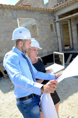 cute young woman architect with handsome foreman in building industry construction site