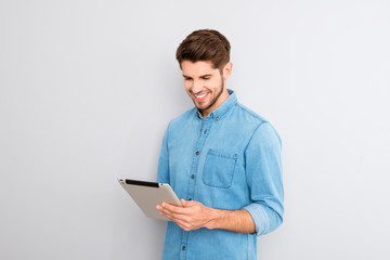 Handsome man using digital tablet on gray background