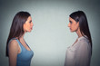 Side profile two young women looking at each other