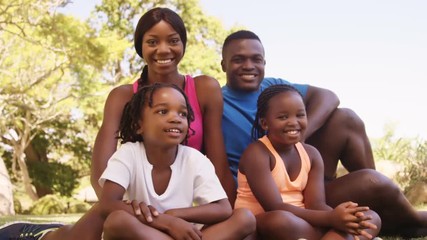 Poster - Cute family is sitting and smiling to the camera 