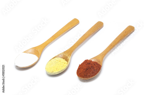 Foto three common spices in wooden spoons isolated on white backgroun