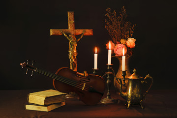 Wall Mural - Jesus Christ on the Cross with violin,accordion,candles,flower and book on black background