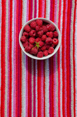 Wall Mural - plate with ripe raspberries stands on striped crocheted doily