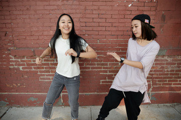 Wall Mural - Young Asian woman dancing hip hop in city