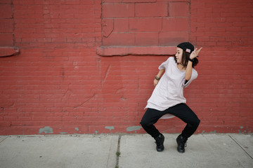 Wall Mural - Young Asian woman dancing hip hop in city