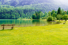 Bench In Green Park And Lake In Alps