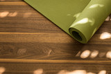 Fototapeta Tulipany - Yoga mat on a wooden background. Equipment for yoga. Concept healthy lifestyle. Lots of copyspace