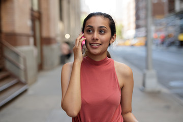 Wall Mural - Young woman in city talking on cell pohne