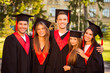 © deagreez - successful joyful five graduates in robes and hats smiling and h