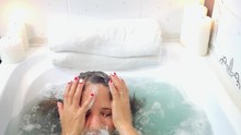 Young Beautiful Woman Relaxing In A Bath, Washing Herself Hair And Face