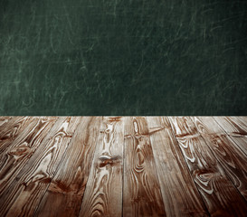 Canvas Print - Wooden table on blackboard background. School concept.