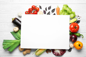 Wall Mural - Fresh vegetables and sheet of paper on wooden background, top view