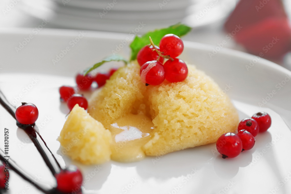 Delicious fondant with red currant on plate, closeup