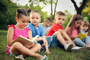 Wall Mural - Group of happy kids reading books in park