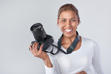 Skilled female photographer holding camera in studio