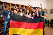 Students With Hands Raised And Smiling Faces Present German Coun