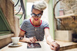© SokRom - Shot of a young stylish woman using a digital tablet in a cafe Coffee and a great book. Life's good