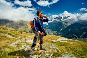 Wall Mural - hiker at the top of a pass with backpack enjoy sunny day in Alps. Switzerland, Trek near Matterhorn mount.