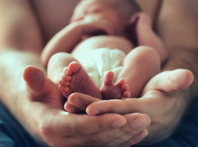 Sleeping Newborn Baby On Male Hands