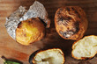 potatoes baked in foil on a wooden background