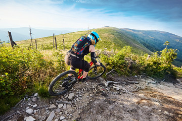 Wall Mural - Young woman riding downhill fullsuspension mountain bike