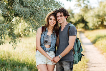 Poster - Young hipster couple standing against trees on the background