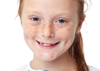 Close up face of a smiling redhead girl with freckles, white background