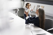 © Westend61 - Senior businesswoman in conference room holding baby girl