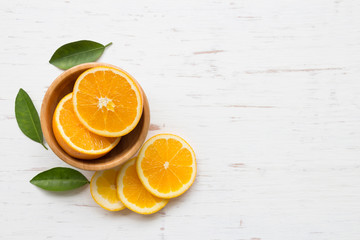 Orange slices in bowl on white rustic wooden background, top view, flat lay