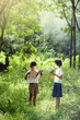 © thanatphoto - Happy children is reading book in rubber plantation