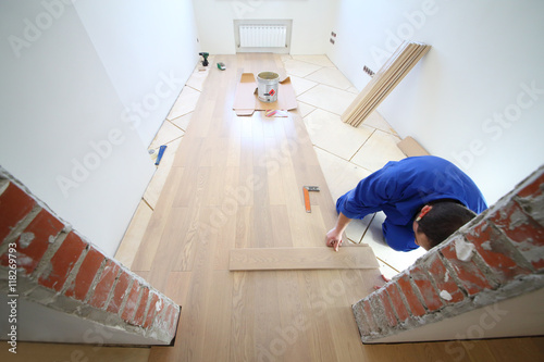 Worker In White Room Where The Laminate Is Laid View Through