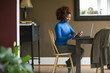 © Inti St Clair/Blend Images - Black woman using cell phone at desk