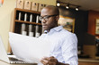 © Roberto Westbrook/Blend Images - Black man using laptop in coffee shop