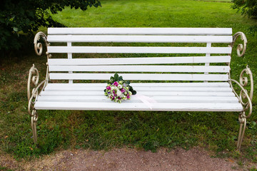 Beautiful bridal bouquet of flowers on wooden bench 