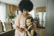© Inti St Clair/Blend Images - Mixed race mother and daughter using cell phone