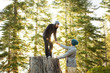© Jim Purdum/Blend Images - Couple playing on tree stump in forest
