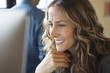 © Sam Diephuis/Blend Images - Close up of smiling businesswoman working at computer