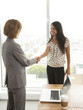 © Sam Diephuis/Blend Images - Businesswomen shaking hands in office