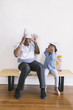 © Hello Lovely/Blend Images - African American grandfather and granddaughter playing on bench