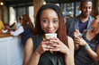 © Granger Wootz/Blend Images - Smiling woman drinking coffee in cafe