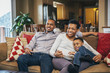 © Inti St Clair/Blend Images - Black family watching television on sofa