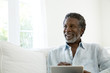 © Jim Purdum/Blend Images - Senior man using digital tablet on sofa