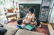© Inti St Clair/Blend Images - Mixed race family playing foosball on living room floor