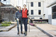 © Jasper Cole/Blend Images - Couple holding rakes in urban rooftop garden
