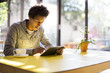 © Resolution Productions/Blend Images - Mixed race man using digital tablet in cafe
