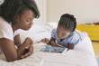 © Hello Lovely/Blend Images - African American mother and daughter using digital tablet