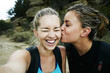 © Peathegee Inc/Blend Images - Woman kissing cheek of friend outdoors