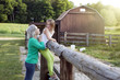© King Lawrence/Blend Images - Caucasian grandmother and granddaughter smiling at farm fence