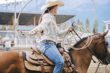 Caucasian Cowgirl Twirling Lasso In Rodeo